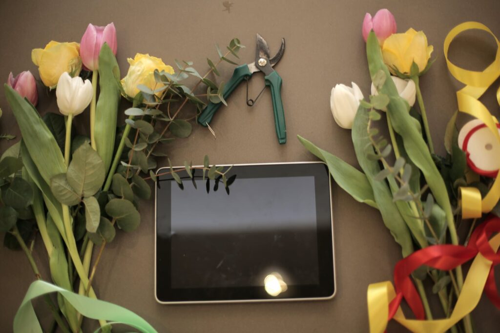 tablet and flower bunches on floral shop counter